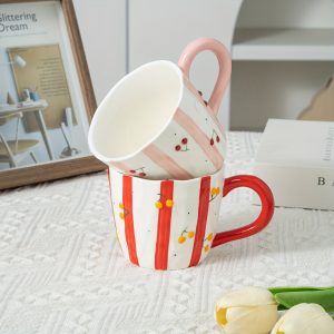 A Creatively Handcrafted Ceramic Coffee And Milk Mug Featuring a Striped Relief Design with Cherries